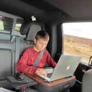 Working on laptop in back seat