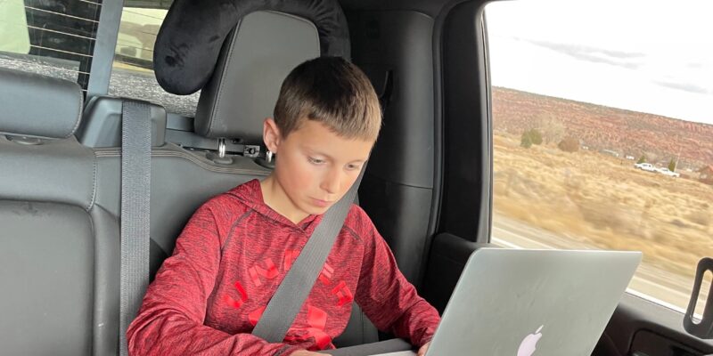 Working on laptop in back seat